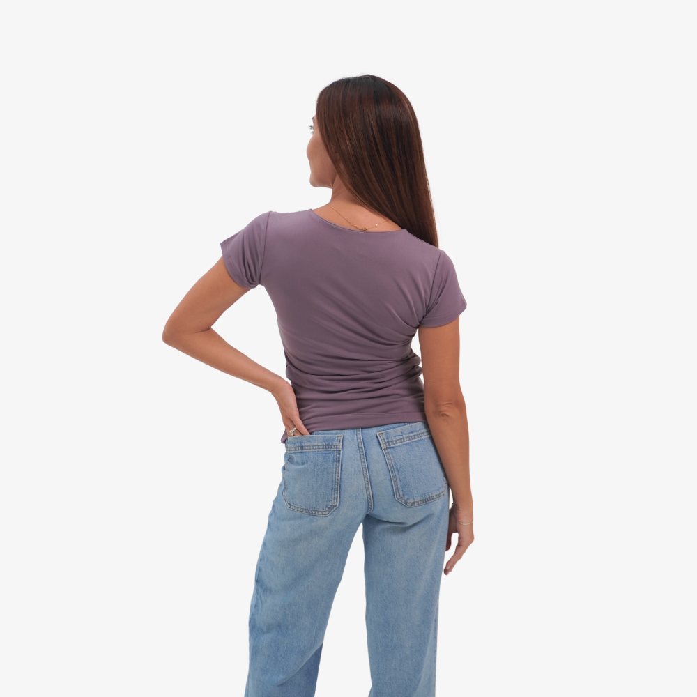 Olivia t-shirt Woman wearing a purple shirt and blue jeans on a white background