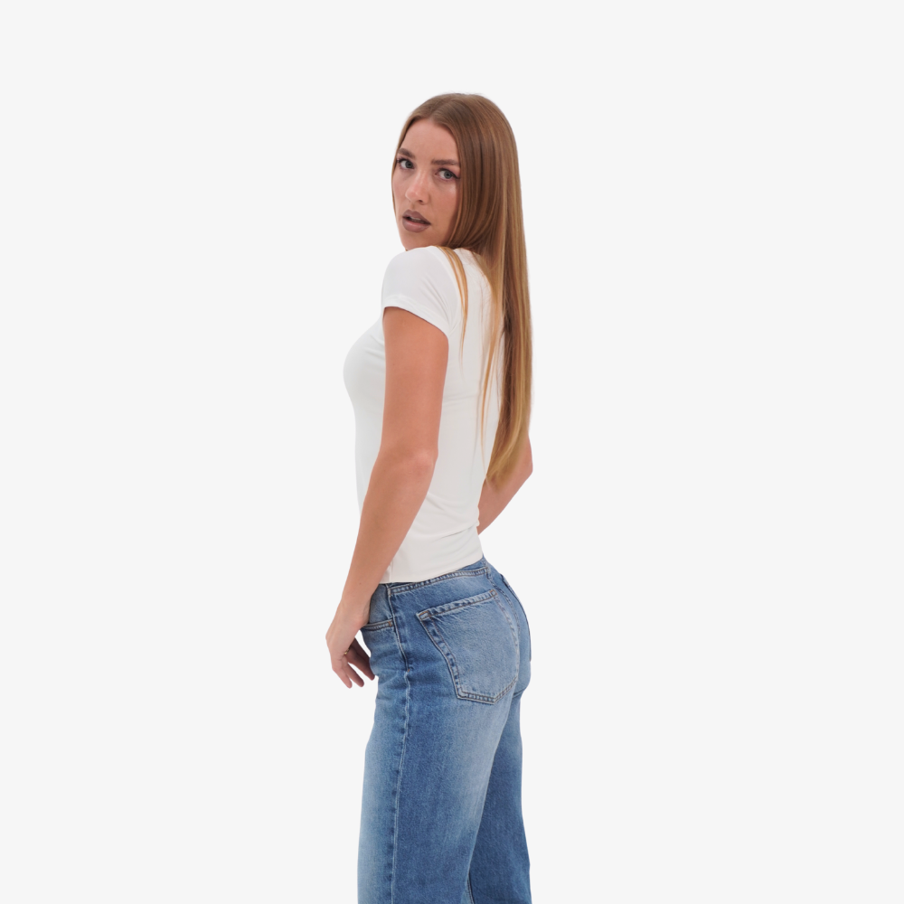 Olivia t-shirt Woman wearing a white t-shirt and blue jeans on a white background