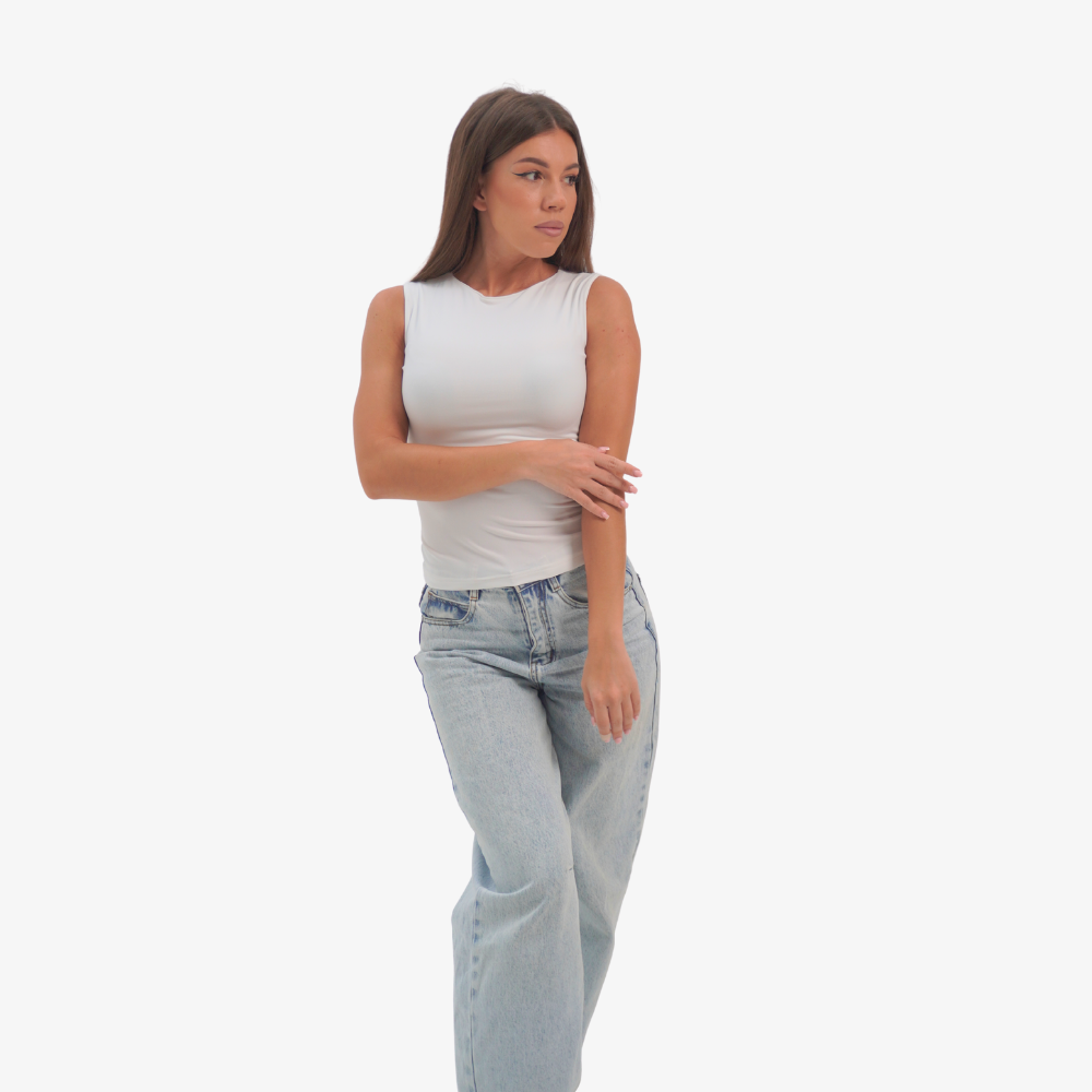 Emma - straight neckline top Woman wearing a white sleeveless top and light blue jeans on a white background